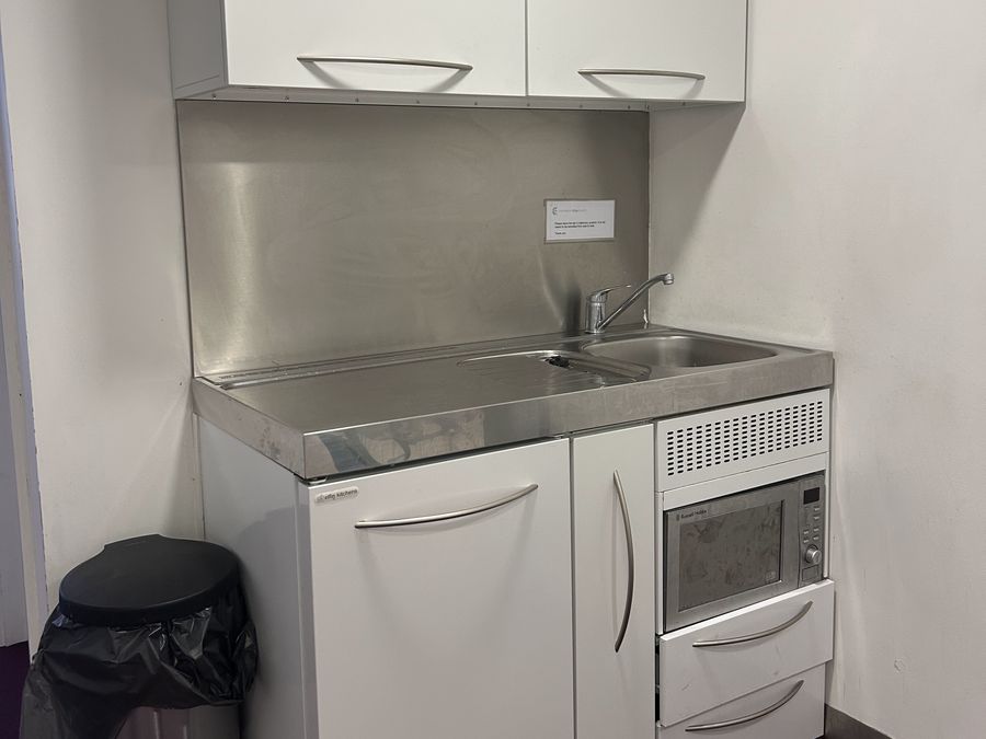 Kitchenette with sink, microwave and cupboards beside the Meeting Room