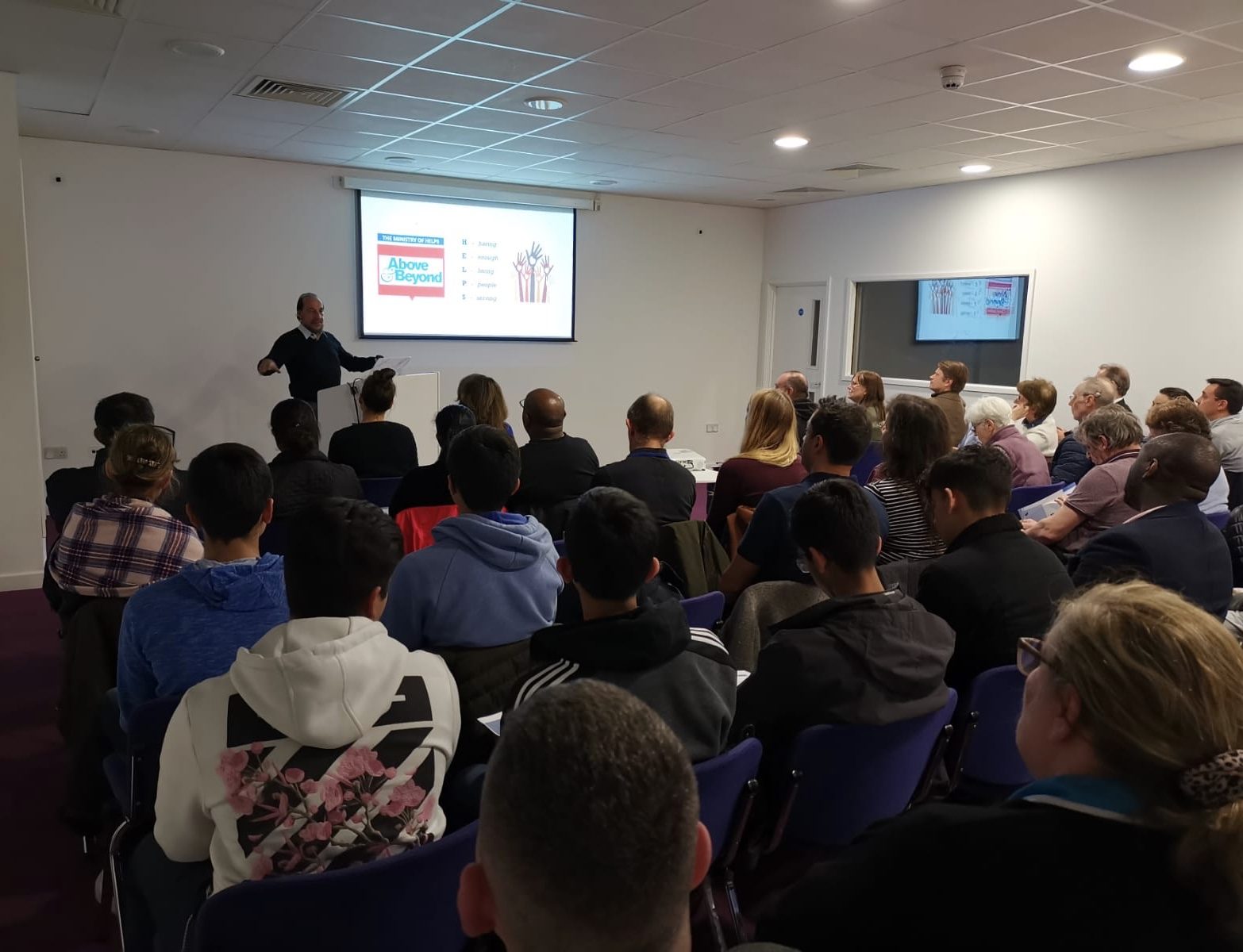 The Meeting Room set up theatre style with a full audience and projector screen